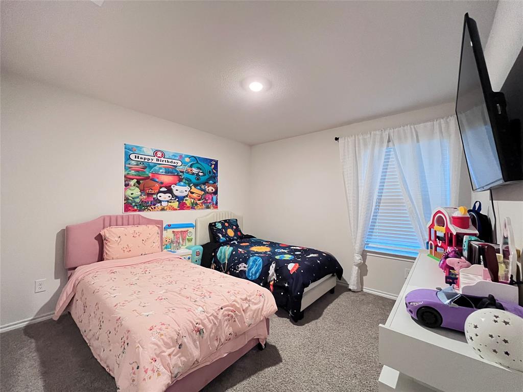 1415 Bent Spur Drive Denton, TX 76207 - Photo 14 of 26 a bedroom with two beds and a flat screen tv