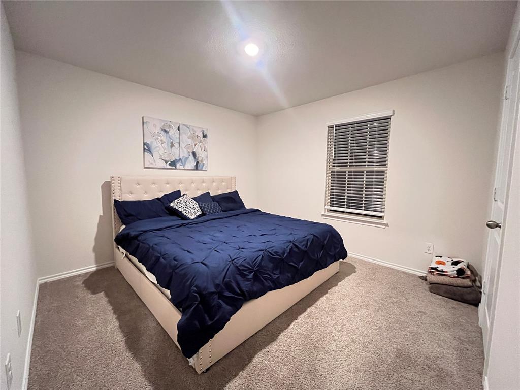 1415 Bent Spur Drive Denton, TX 76207 - Photo 17 of 26 a spacious bedroom with a bed and a window