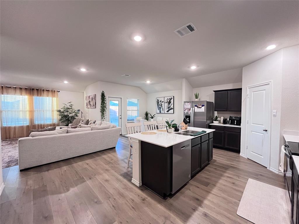 1415 Bent Spur Drive Denton, TX 76207 - Photo 26 of 26 a large kitchen with kitchen island a sink a counter top space and stainless steel appliances