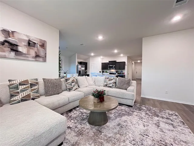 a room with stainless steel appliances a table and a chair