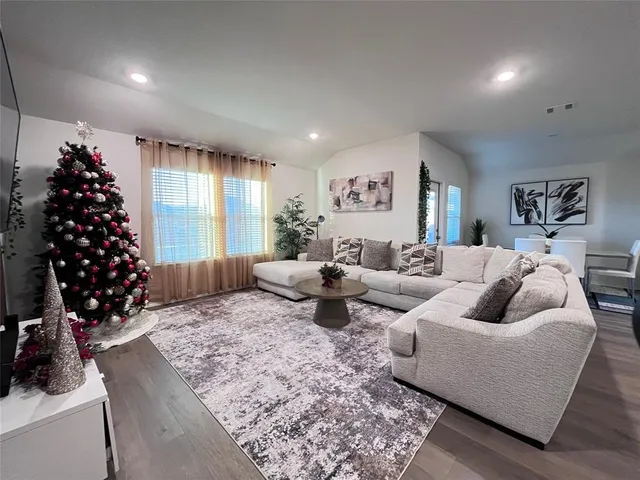 a living room with furniture and a view of kitchen