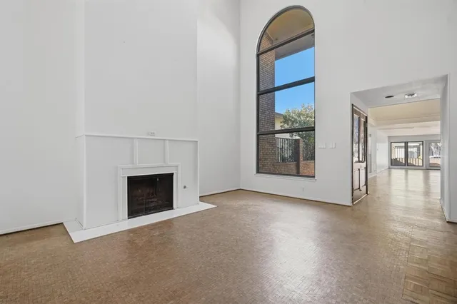 a view of an empty room with window and fire place