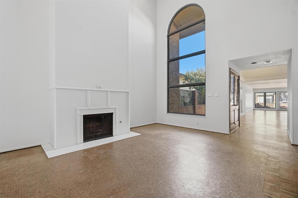 a view of an empty room with window and fire place