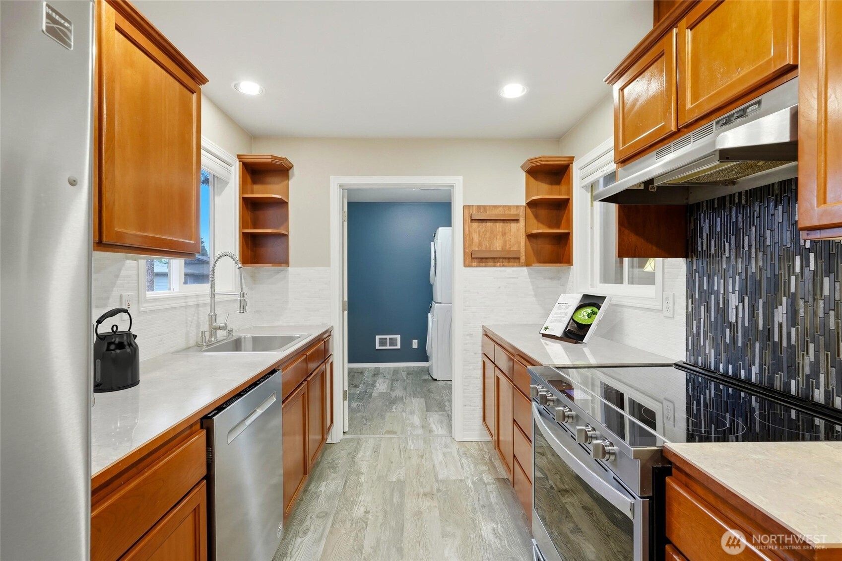 7809 218th Street Southwest, Unit 12 Edmonds, WA 98026 - Photo 11 of 34 a kitchen with stainless steel appliances granite countertop a sink a stove and a wooden floors