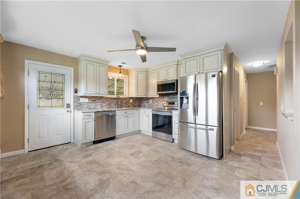 37 Oxford Road Colonia, NJ 07067 - Photo 8 of 24 a kitchen with white cabinets and stainless steel appliances