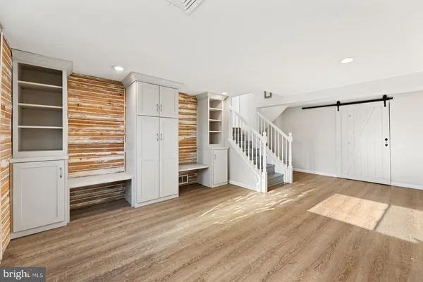 a view of an empty room with stairs and a window