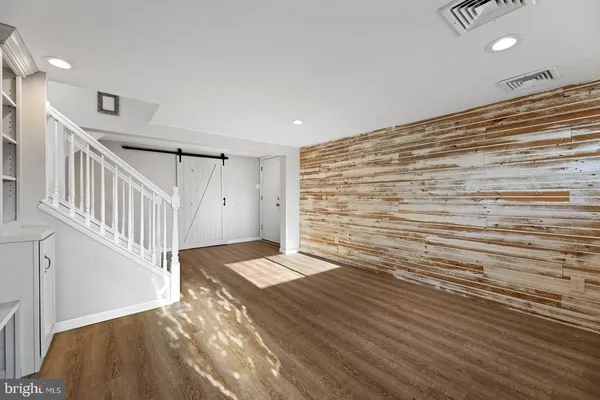 a view of a livingroom with wooden floor and stairs