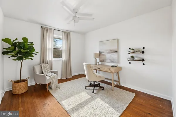 an empty room with wooden floor and ceiling fan