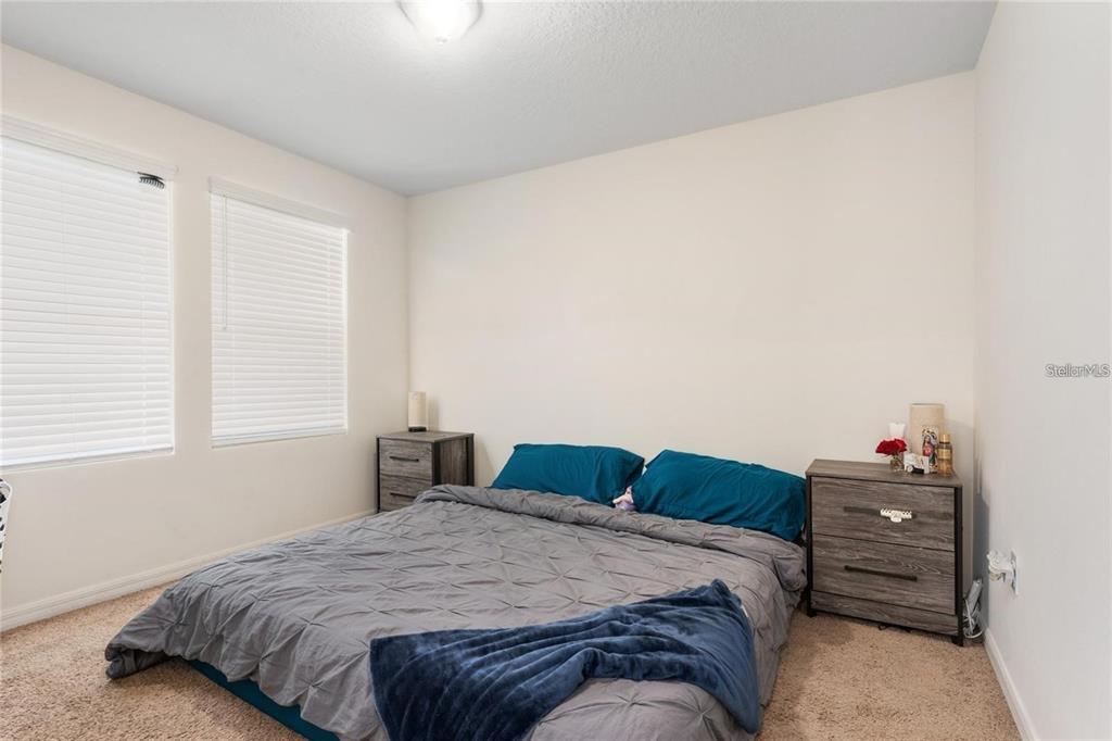 2449 Varenna Loop Kissimmee, FL 34741 - Photo 13 of 25 a bedroom with a bed and window