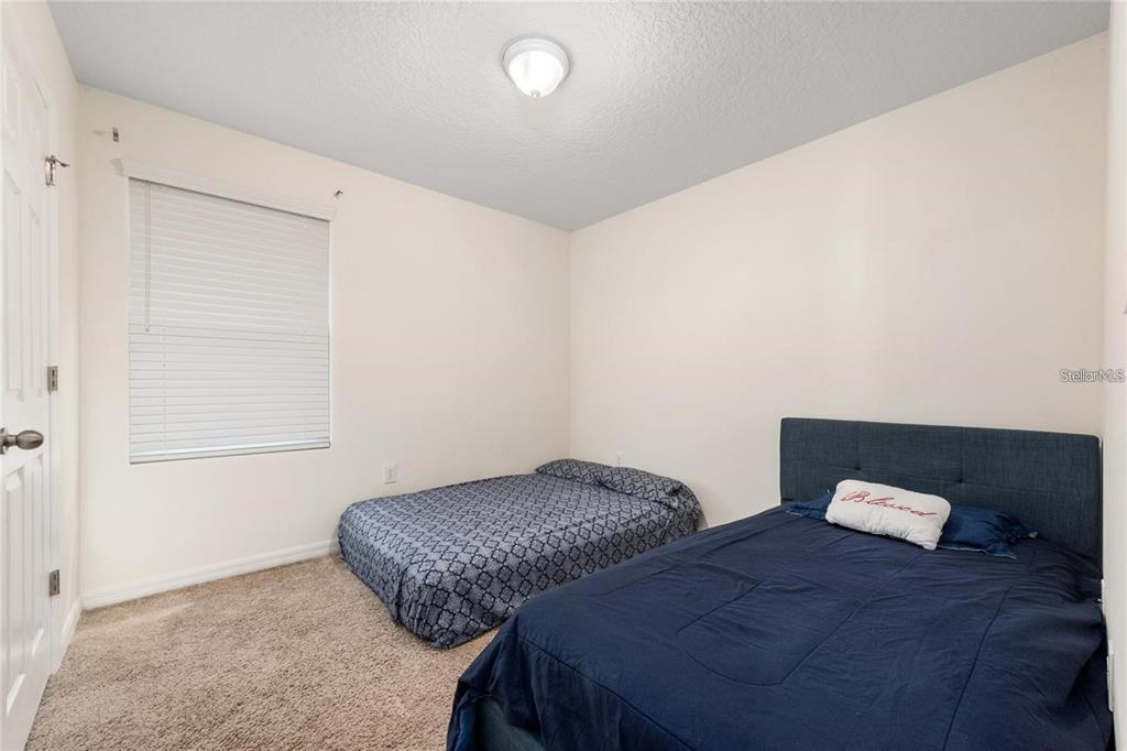 2449 Varenna Loop Kissimmee, FL 34741 - Photo 15 of 25 a bedroom with two beds and a window