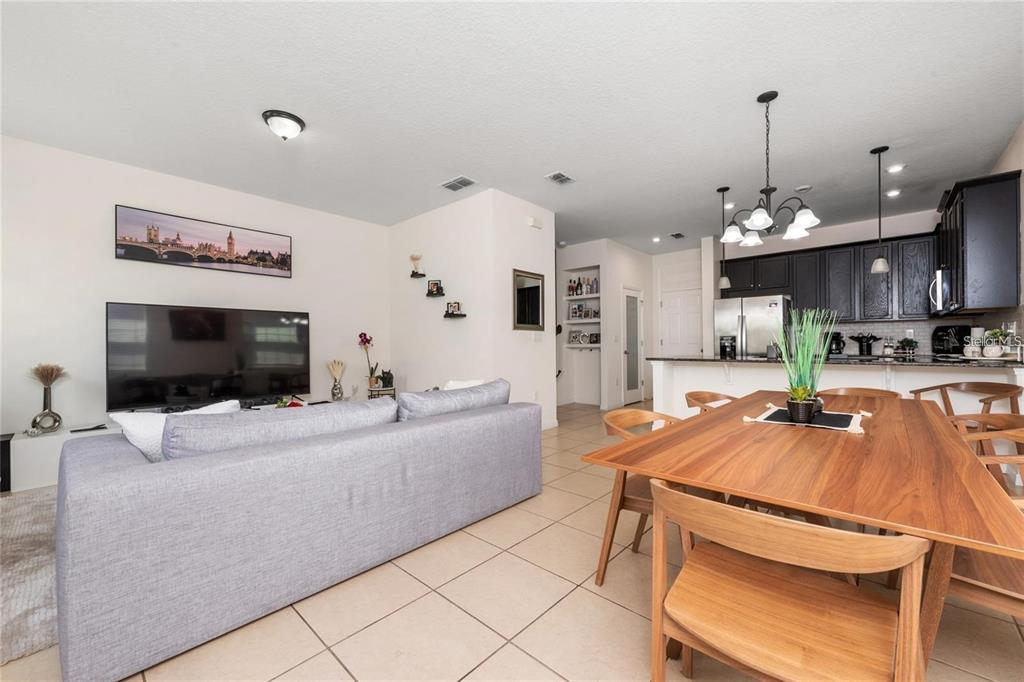 2449 Varenna Loop Kissimmee, FL 34741 - Photo 6 of 25 a living room with furniture and a flat screen tv