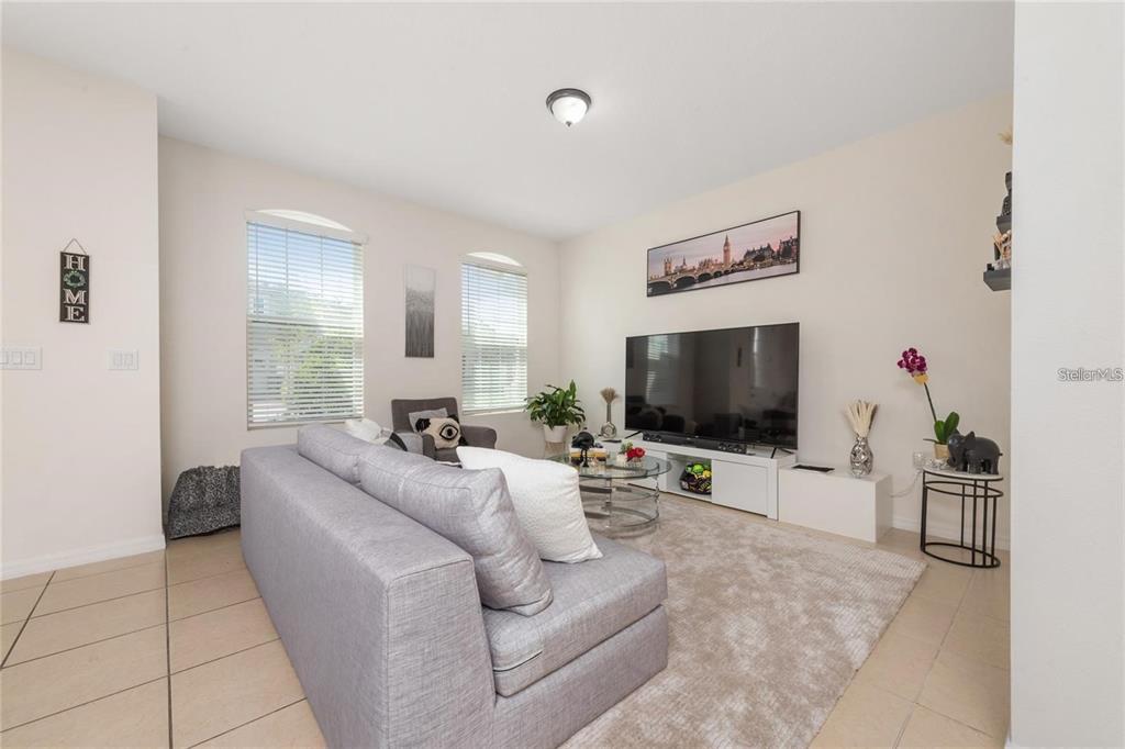 2449 Varenna Loop Kissimmee, FL 34741 - Photo 7 of 25 a living room with furniture and a flat screen tv