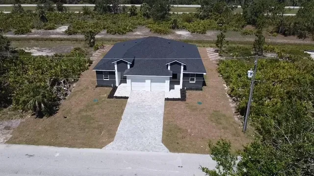 an aerial view of a house with yard