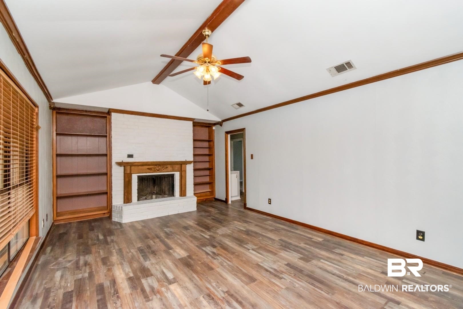 8304 Champlain Circle Mobile, AL 36695 - Photo 20 of 46 Unfurnished living room featuring a brick fireplace, vaulted ceiling with beams, hardwood / wood-style floors, and built in features