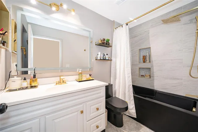 a bathroom with a sink a toilet and a mirror