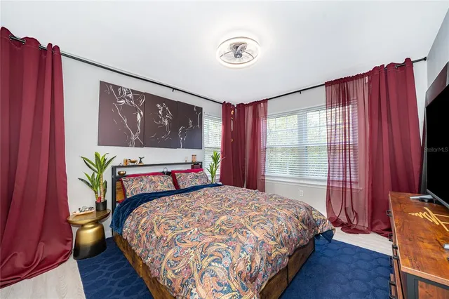 a bedroom with a bed a dresser next to a window