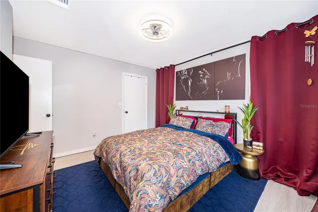 a bedroom with a bed and wooden floor