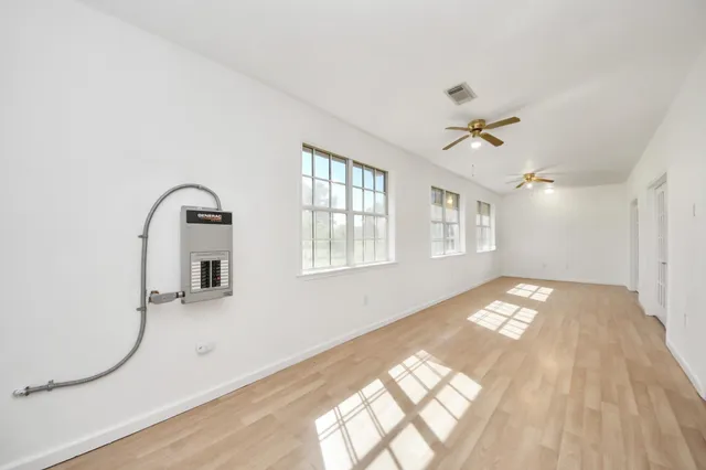 a view of a bedroom with wooden floor and windows