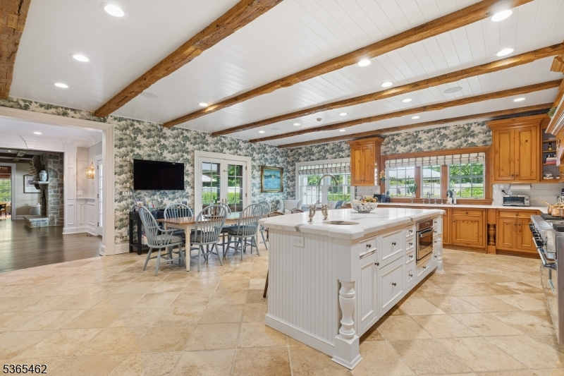 119 Mosle Road Far Hills, NJ 07931 - Photo 12 of 50 a large white kitchen with kitchen island a large window a sink and chairs