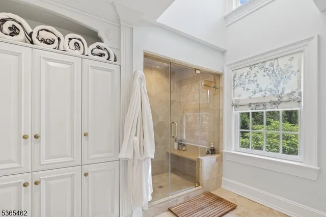 a bedroom with a bed a couch and large window