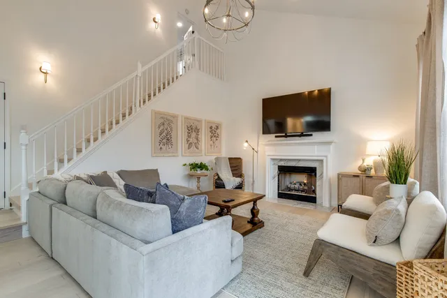 a living room with furniture a fireplace and a flat screen tv