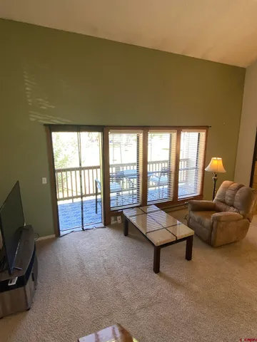 a living room with furniture and a floor to ceiling window