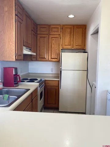 a kitchen with stainless steel appliances granite countertop a refrigerator a stove a sink and a refrigerator