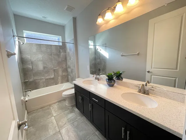 a bathroom with a tub sink shower and a mirror
