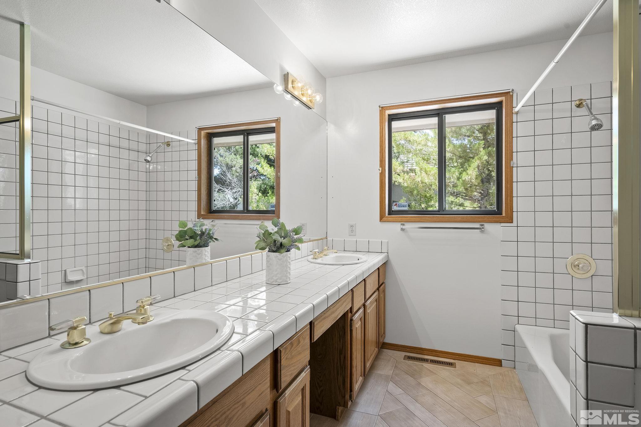 15 Pecetti Circle Reno, NV 89511 - Photo 20 of 40 a bathroom with a granite countertop sink a mirror and a shower