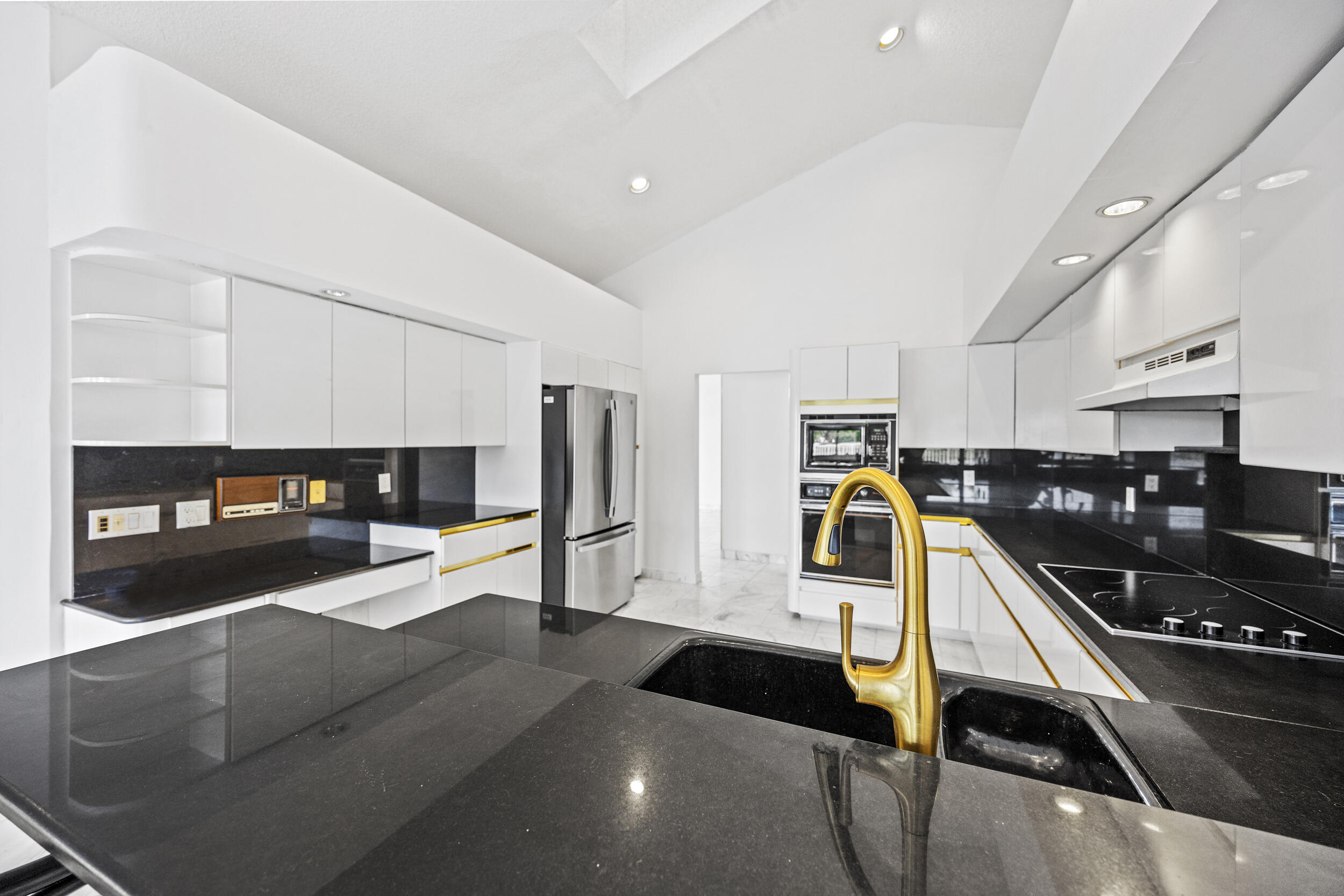 10747 Stonebridge Boulevard Boca Raton, FL 33498 - Photo 19 of 75 a kitchen with stainless steel appliances kitchen island granite countertop a refrigerator and stove top oven with wooden floor