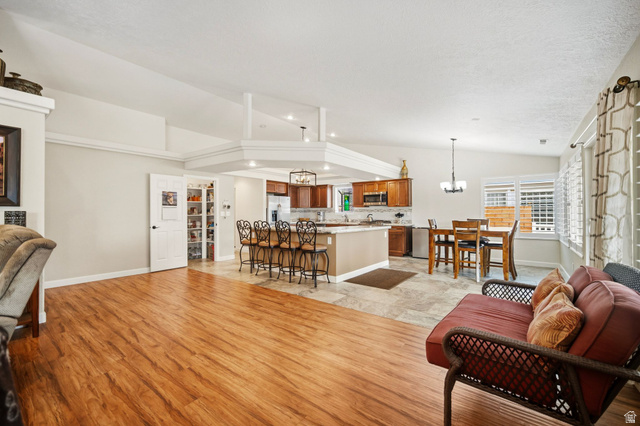 1985 West Rivers Edge Lane St. George, UT 84770 - Photo 16 of 42 Living area featuring lofted ceiling, suspended lighting, and light wood-type flooring