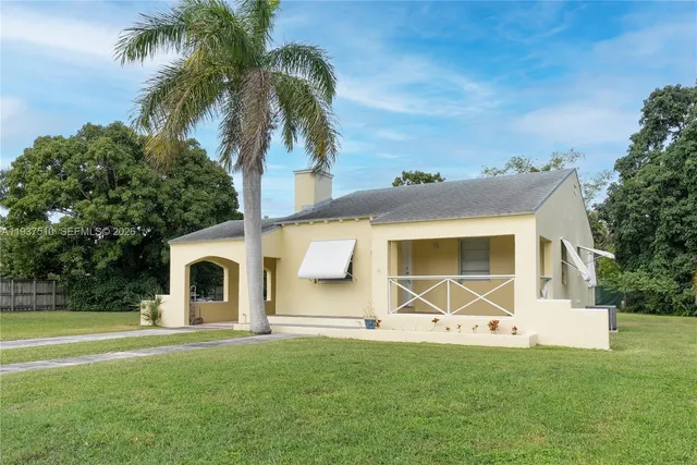 a backyard of a house with table and chairs