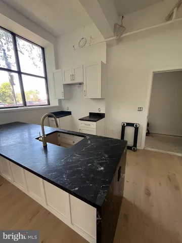 a kitchen with granite countertop a sink a stove and a window