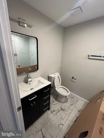 a bathroom with a sink toilet and mirror