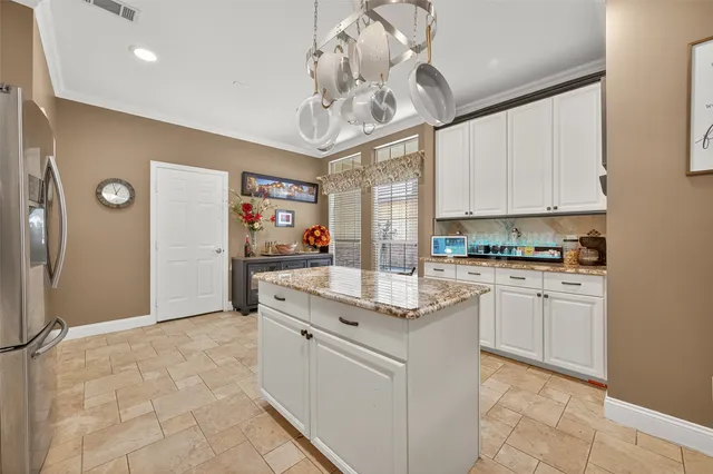 a kitchen with stainless steel appliances granite countertop a refrigerator and a stove top oven