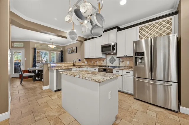 a kitchen with kitchen island a sink stainless steel appliances and cabinets