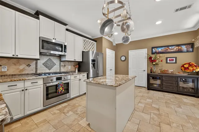 a kitchen with stainless steel appliances granite countertop a sink and cabinets