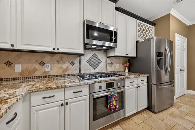 a kitchen with stainless steel appliances granite countertop a stove a refrigerator and a microwave