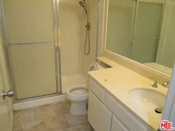 a bathroom with a granite countertop sink toilet and shower