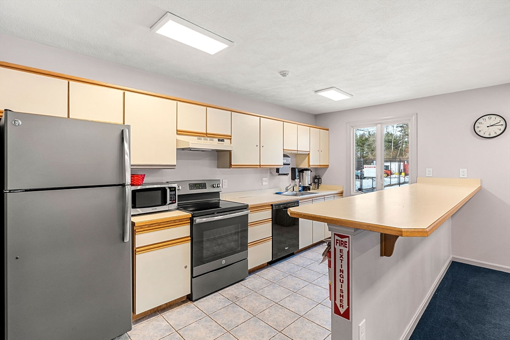 4 Iris Way, Unit 22 Haverhill, MA 01830 - Photo 35 of 38 a kitchen with kitchen island a sink a counter appliances and cabinets