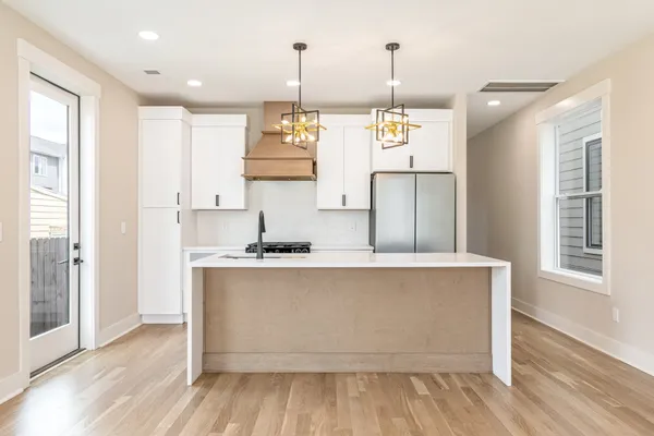 a kitchen with stainless steel appliances granite countertop a sink a stove and a wooden floors
