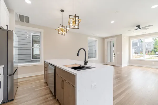 a view of a kitchen with a sink and dishwasher wooden floor