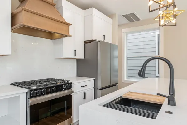 a kitchen with stainless steel appliances a stove a refrigerator and a cabinets