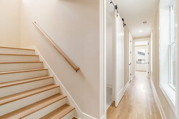 a view of a hallway with wooden floor and entryway