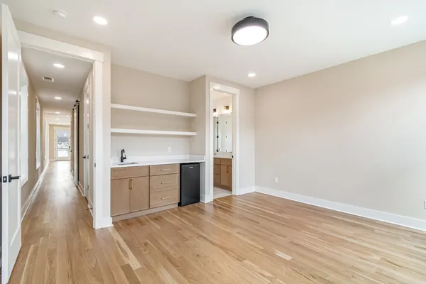 wooden floor in an empty room with a kitchen