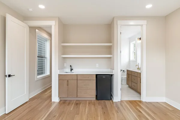 a view of a kitchen from the hallway with wooden floor and cabinet