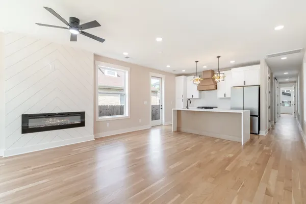 a large kitchen with stainless steel appliances kitchen island a large counter top and a wooden floors