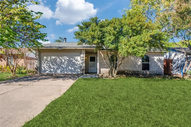 front view of a house with a yard and an trees