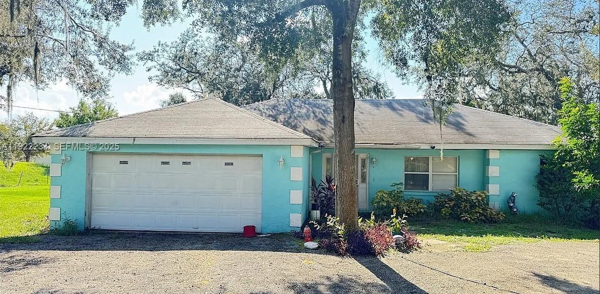 a front view of a house with a yard and tree