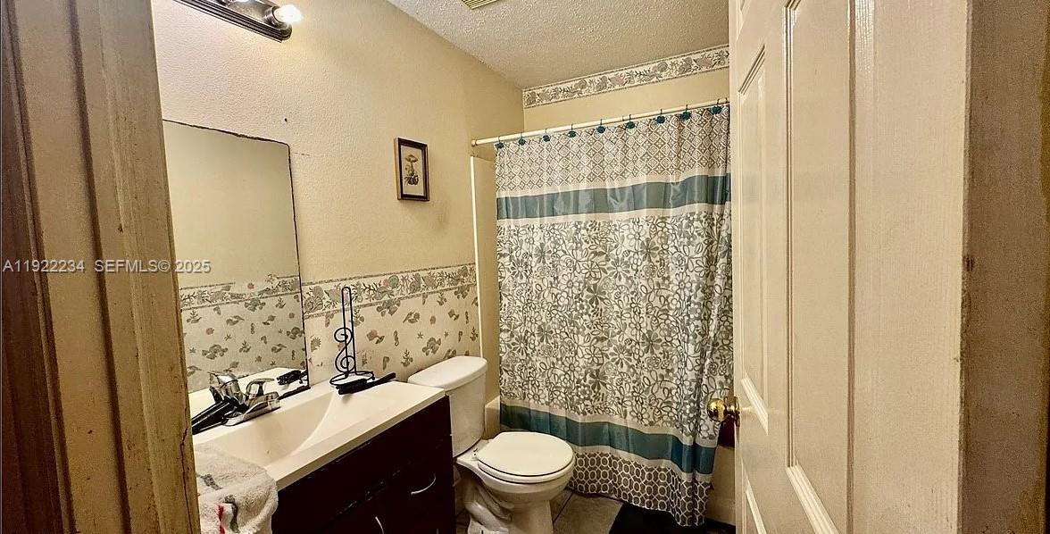 8055 Twitty Road Sebring, FL 33876 - Photo 16 of 19 a bathroom with a sink a toilet and shower curtain
